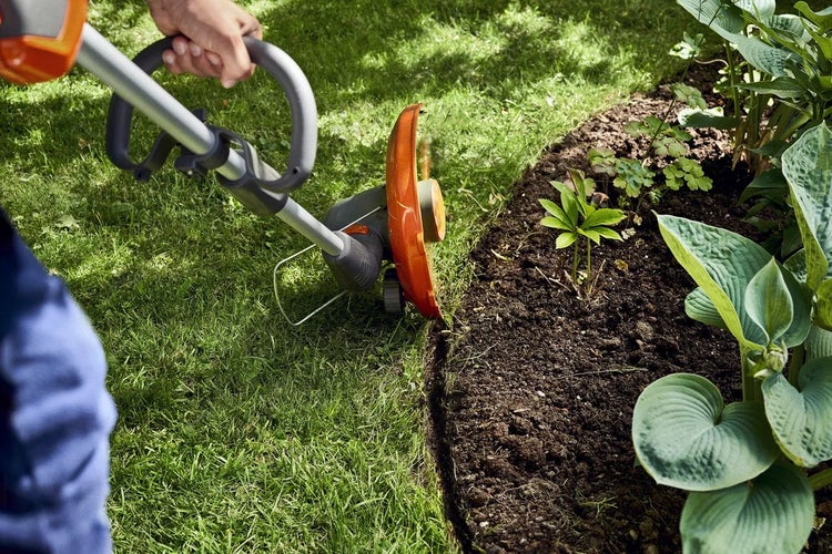 Rasentrimmer im Einsatz zum Kantenschneiden im Garten.