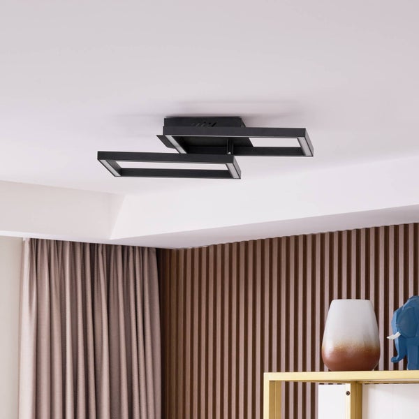 Moderne schwarze LED-Deckenleuchte mit zwei rechteckigen Rahmen in einem hellen Raum mit Holzlamellenwand und Vorhängen.