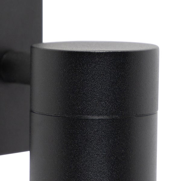 Nahaufnahme einer zylindrischen schwarzen Außenwandleuchte aus mattiertem Metall.