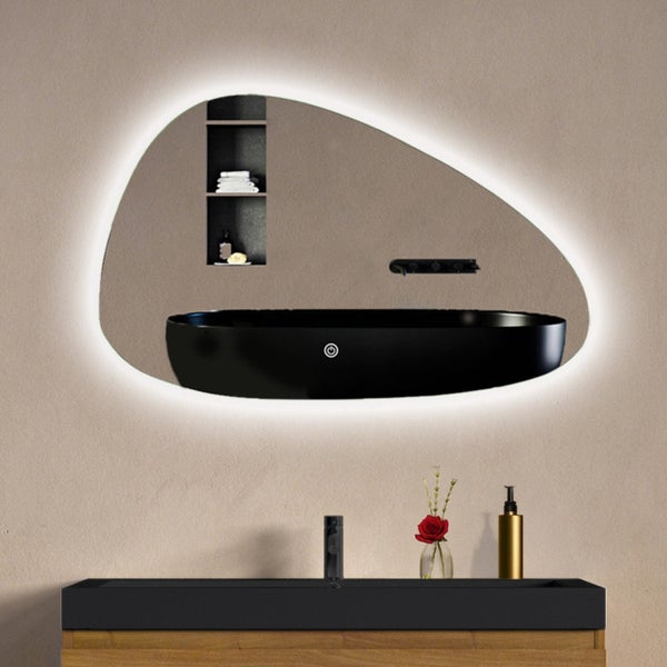 Organisch geformter Badezimmerspiegel mit LED Beleuchtung und Touchschalter montiert über einem Waschtisch mit schwarzem Waschbecken.