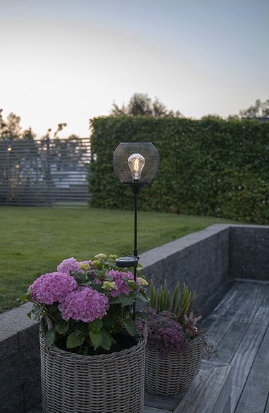 Dekorative Solarleuchte im Garten mit Blumenkübel