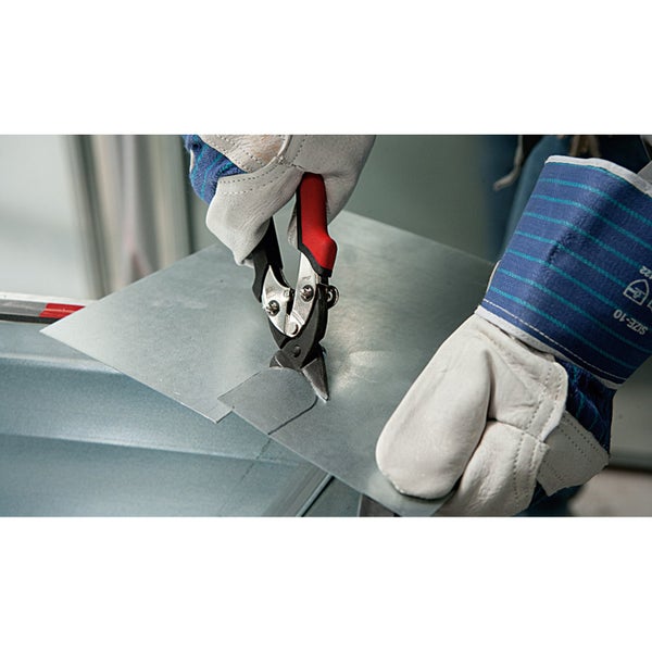 Blechschere beim Schneiden von Metallblech, Person trägt Arbeitshandschuhe.