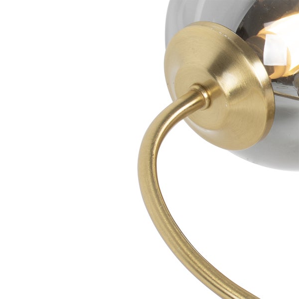 Nahaufnahme einer Wandleuchte mit Messingarm und grauer Glaskugel