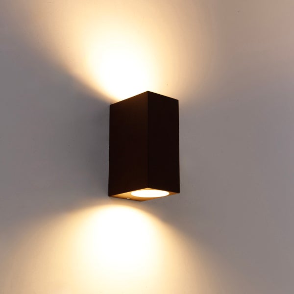 Moderne schwarze Wandlampe in rechteckiger Form mit Up-and-Down-Lichteffekt an einer Wand.