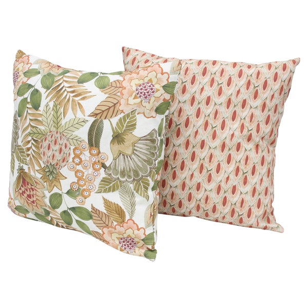 Zwei quadratische Dekokissen mit floralen Mustern auf einem hellen Sofa platziert