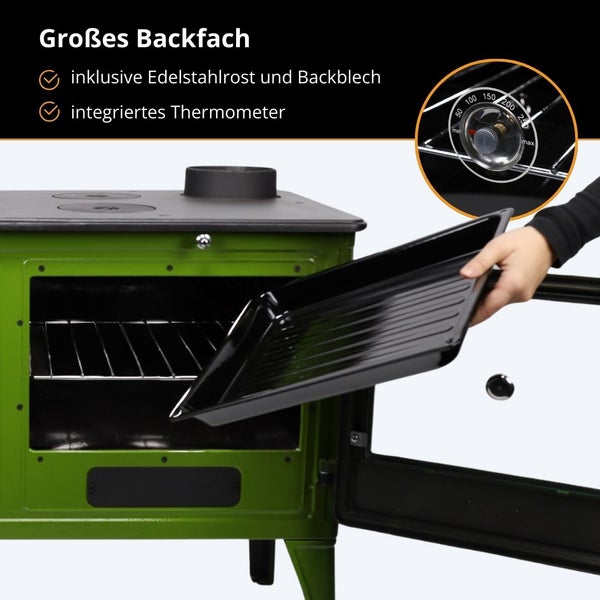 Grüner Holzherd mit offenem Backfach, inklusive Backblech und Edelstahlrost sowie einem integrierten Thermometer.