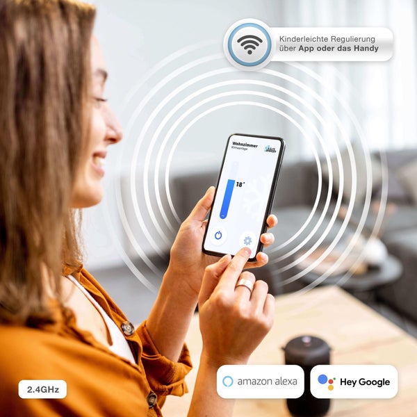 Eine Frau steuert eine Klimaanlage über eine App auf ihrem Smartphone. Amazon Alexa Logo und Google Logo. 2.4 Gigahertz Verbindung.