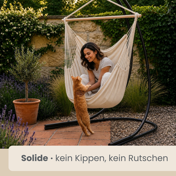 Frau in einem Hängesessel mit Gestell im Garten, daneben eine Katze, stimmungsvolle Gartengestaltung mit Pflanzen und Steinmauer.