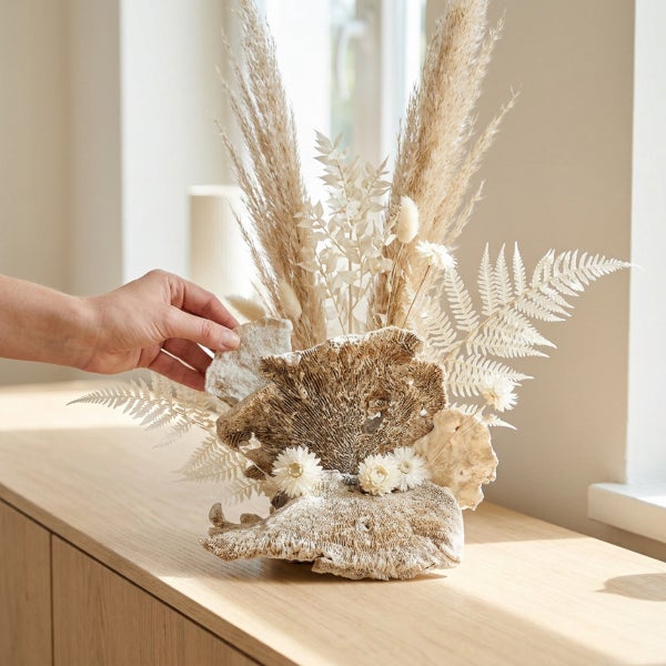 Dekorative Trockenblumen und Korallen im Gesteck auf einem Holzschrank platziert.
