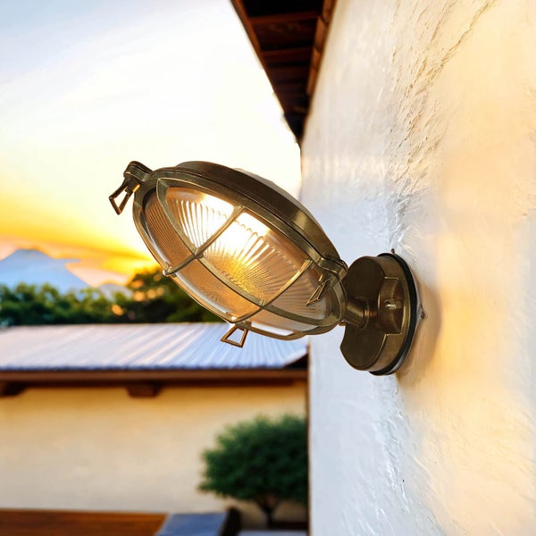 Wandleuchte aus Metall mit Schutzgitter an einer Wand