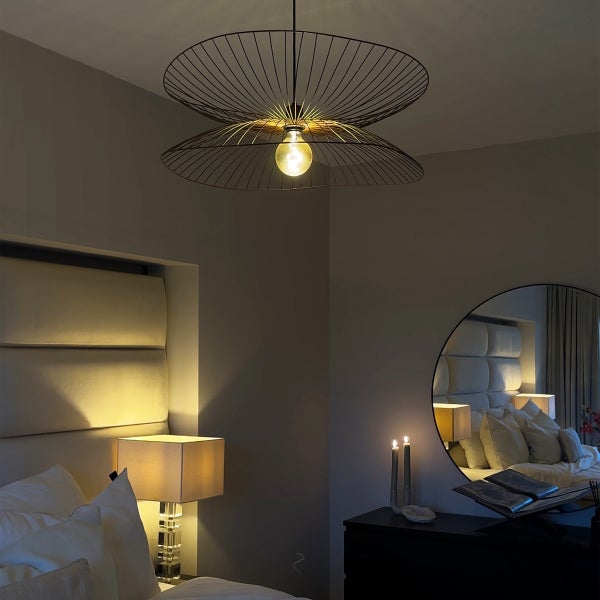 Schlafzimmer mit einem Bett und einer dekorativen Pendelleuchte