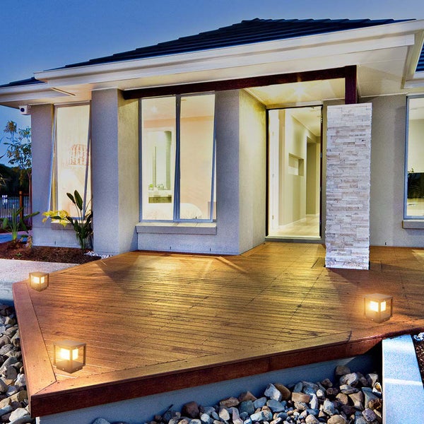 Außenansicht eines Hauses mit Holzterrasse und dekorativer Beleuchtung