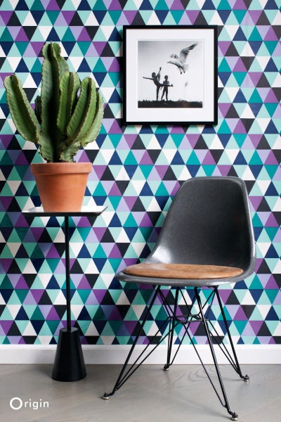 Wohnraum mit gemusterter Tapete, Stuhl, Tisch und Kaktus