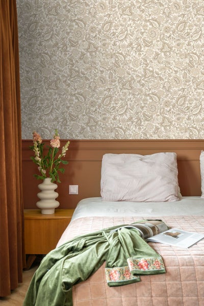 Schlafzimmer mit floral gemusterter Tapete in Beige, weißer Wandverkleidung, einem Holzbett und einem weißen Nachttisch.