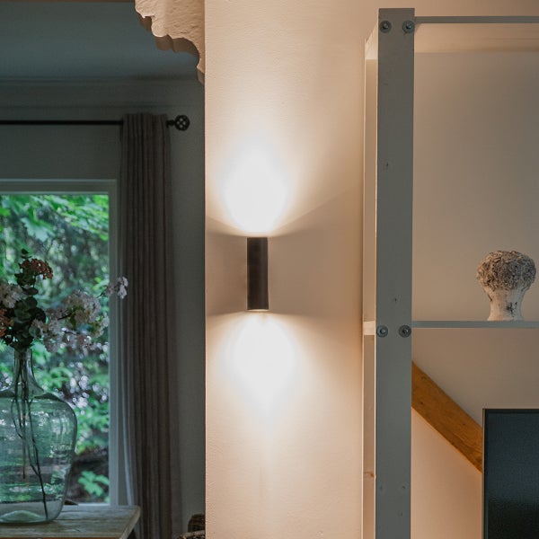 Wohnraum mit Wandleuchte, Regal und Fenster