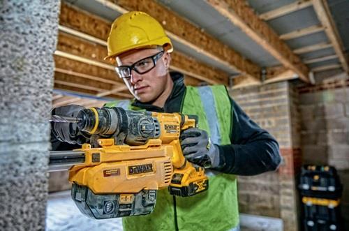 Ein Bauarbeiter bohrt mit einem DeWalt Bohrhammer ein Loch in eine Wand.