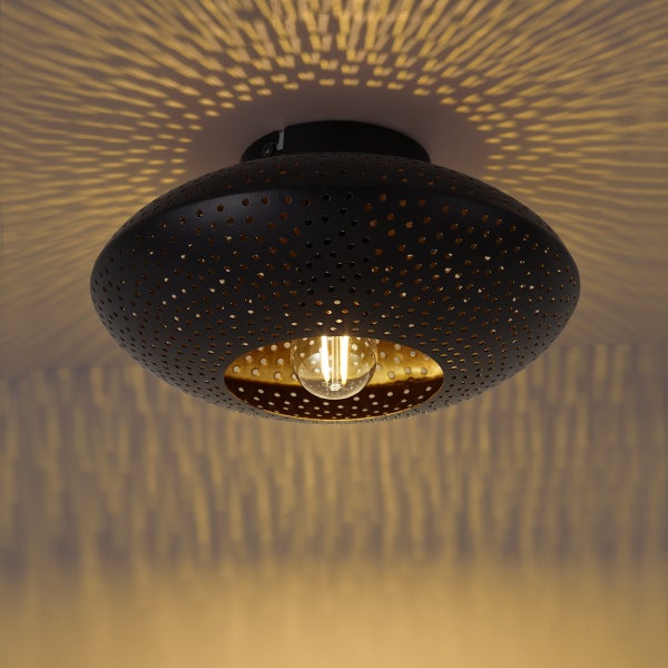 Runde Deckenleuchte aus Metall mit Lochmuster für effektvolle Lichtstrahlen an der Decke.