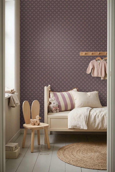 Hell eingerichtetes Kinderzimmer mit floral gemusterter Tapete, weißem Holzbett, einem Stuhl in Hasenform und einem runden Jute-Teppich.