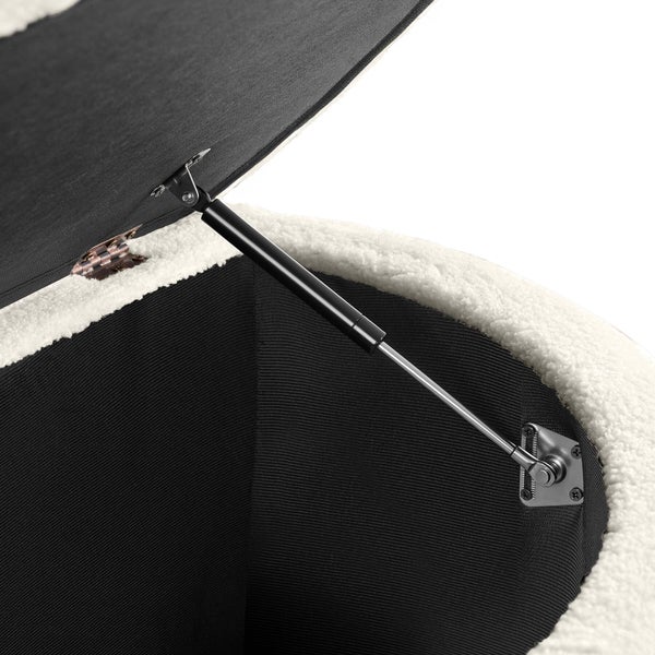 Detailaufnahme eines Gasdruckdämpfers an einer Sitztruhe mit weißem Teddy-Stoff und schwarzem Innenraum.