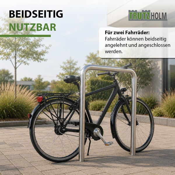 Fahrradanlehnbügel aus Edelstahl von Trutzholm für zwei Fahrräder beidseitig nutzbar auf einem gepflasterten Außenbereich.