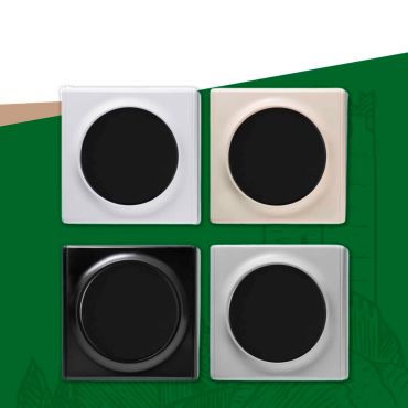 Vier quadratische Lichtschalter mit rundem Einsatz in verschiedenen Ausführungen als Teil eines Schalterprogramms.
