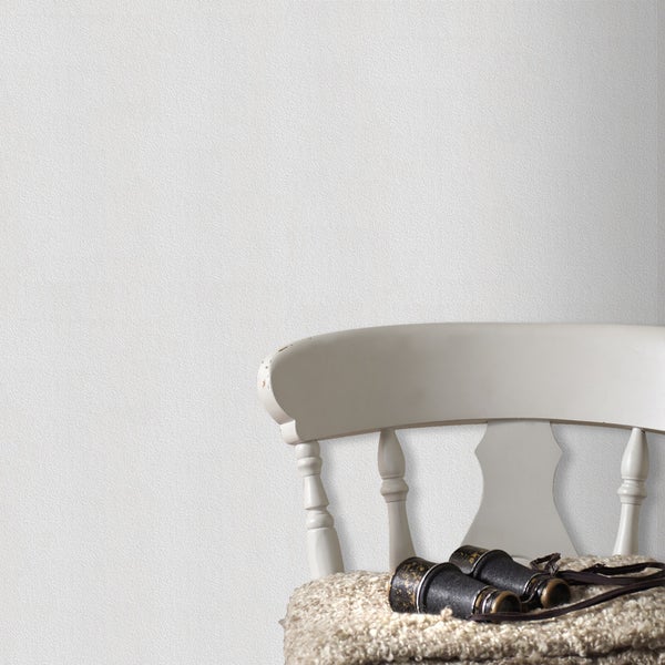 Nahaufnahme einer Raufasertapete mit Stuhl und Fernglas