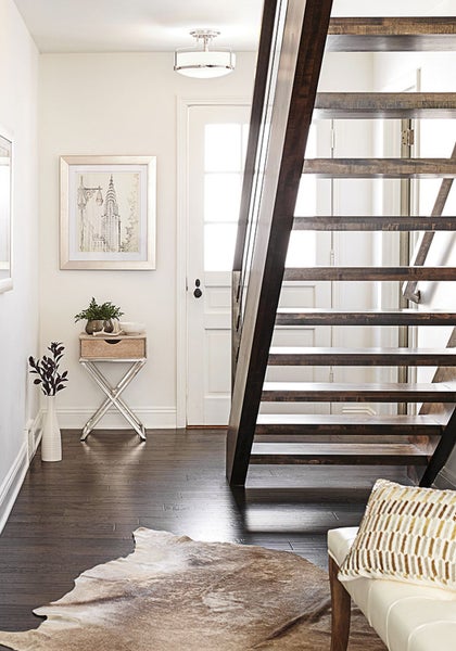 Eingangsbereich mit Holztreppe, Tisch, Dekoration und Teppich
