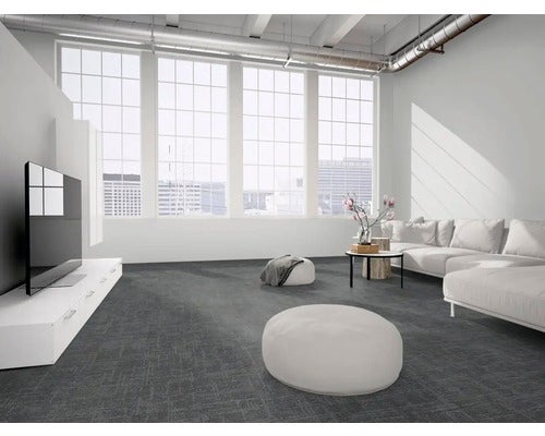 Modernes, helles Wohnzimmer mit dunkelgrauem Teppichboden, weißem Sofa, großen Fenstern und einer Decke im Industriestil.