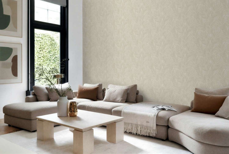 Wohnzimmer mit Vliestapete mit feinem Blättermuster in einem hellen, modernen Raum mit großem Sofa.
