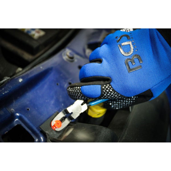 Hand mit Arbeitshandschuh montiert Stecker am Auto