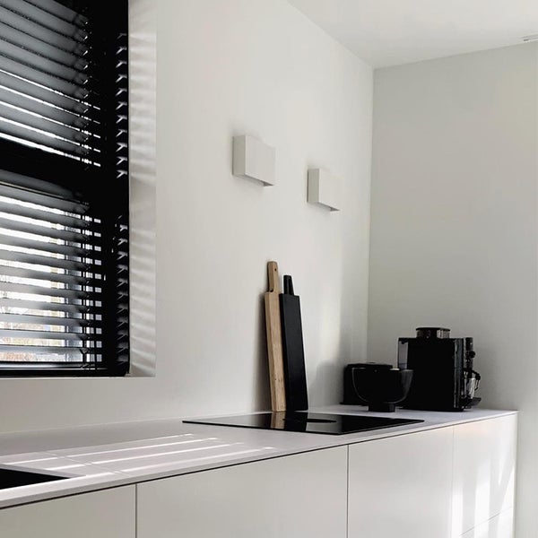 Helle Küche mit Jalousien, Kochfeld und Küchenutensilien