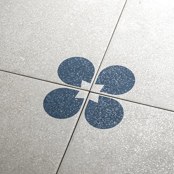 Feinsteinzeug Bodenfliese in Terrazzo Optik mit florales Dekorelement im Kreuzungspunkt der Fliesen