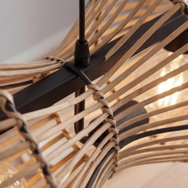 Detailansicht einer Pendelleuchte mit hellen Holzlamellen auf einem schwarzen Metallgestell und eingeschaltetem Leuchtmittel.