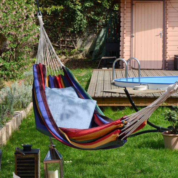 Gestreifte Hängematte aus Stoff mit einer darin liegenden Frau.