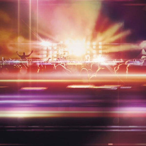 Konzertszene mit jubelnder Menge vor der Bühne mit Lichteffekten