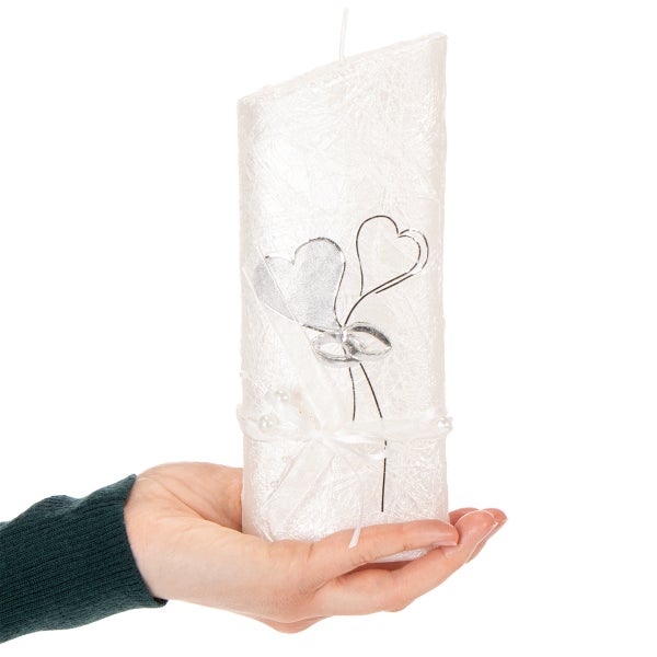 Weiße Hochzeitskerze mit Herzen, Eheringen und einer Schleife mit Perlen.