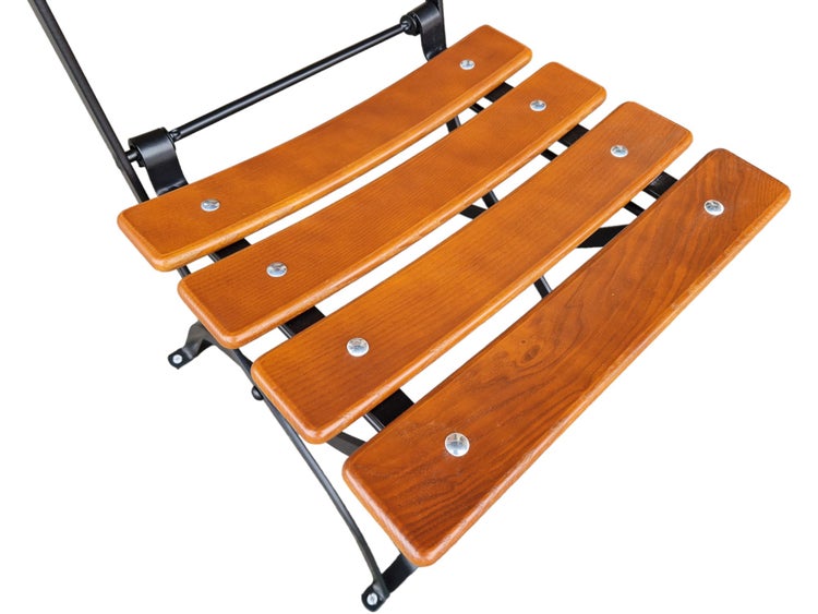 Detailansicht der Sitzfläche eines Klappstuhls mit vier gebogenen Holzlatten und einem schwarzen Metallgestell.