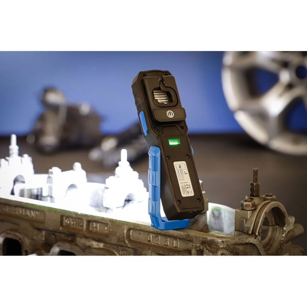 LED Arbeitsleuchte steht auf einem Motorbauteil in einer Werkstatt und beleuchtet den Arbeitsbereich hell für mechanische Arbeiten.