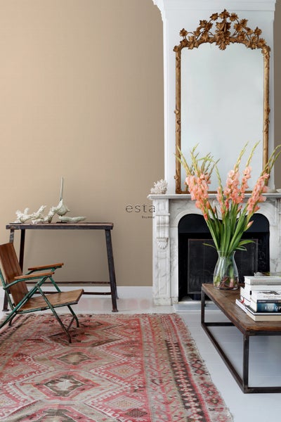 Wohnzimmer mit antikem Teppich, Sessel, Tisch und Kamin