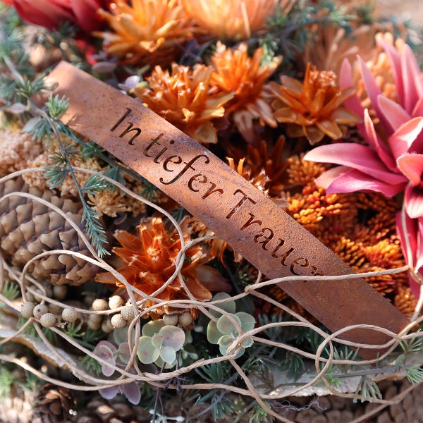 Gesteck mit Trockenblumen und Schriftzug in tiefer Trauer