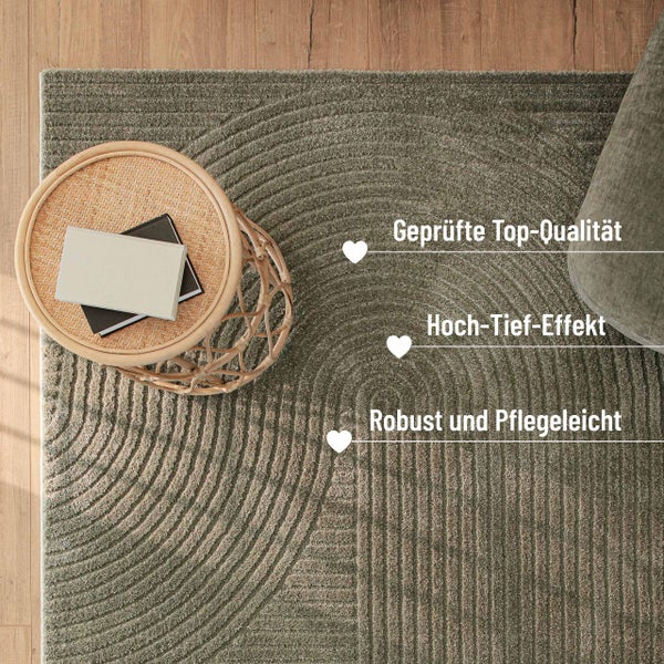 Robuster, pflegeleichter Teppich mit Hoch-Tief-Effekt und bogenförmigem Muster in geprüfter Qualität auf Holzfußboden neben Rattantisch.