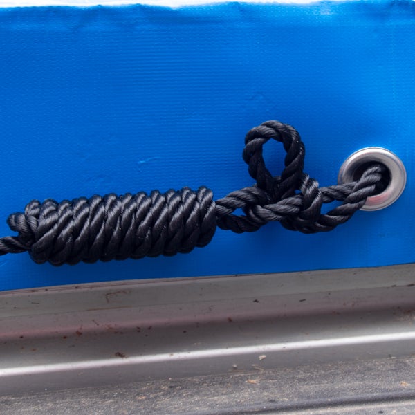 Detailaufnahme eines blauen Planenverdeck mit schwarzem Gummiseil zur Befestigung