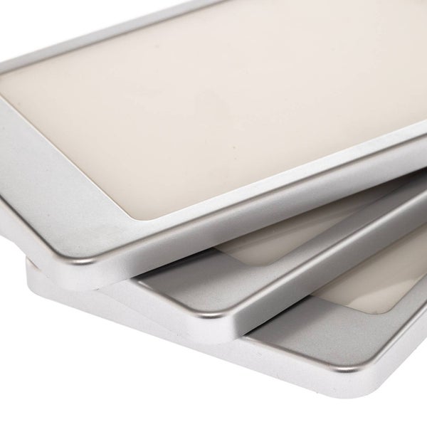 Drei flache, rechteckige LED-Möbelleuchten mit silberfarbenem Rahmen und matter Lichtfläche, schräg gestapelt.