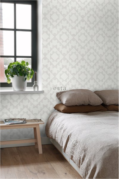 Schlafzimmer mit Bett, Beistelltisch und geometrischer Tapete