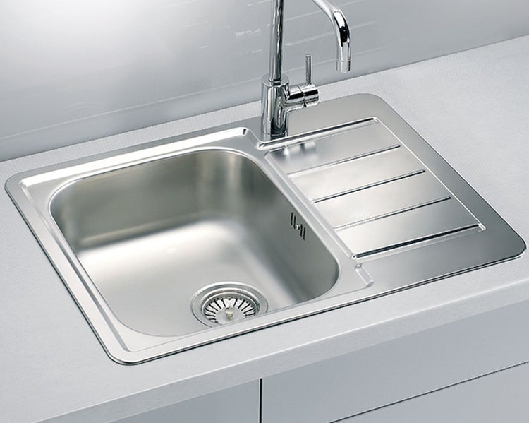 Einbau-Küchenspüle aus Edelstahl mit Abtropffläche und montierter Küchenarmatur in einer Arbeitsplatte.