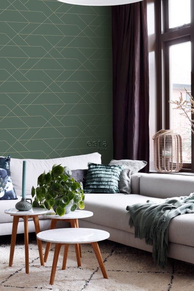 Wohnzimmer mit grüner Tapete mit geometrischem Muster, Sofa und Beistelltischen.