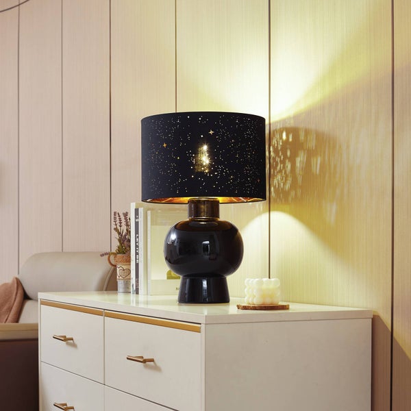 Dekorative Tischleuchte mit Sternenmuster auf einer Kommode