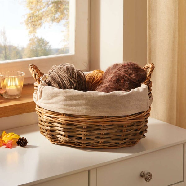 Dekorative Korb mit Garn auf einem Tisch vor einem Fenster.