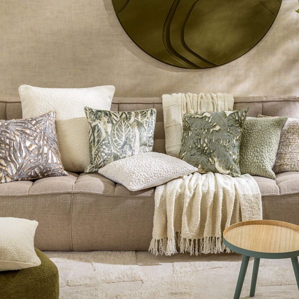 Wohnzimmer Szene mit Sofa, Kissen, Tagesdecke, Teppich und Beistelltisch