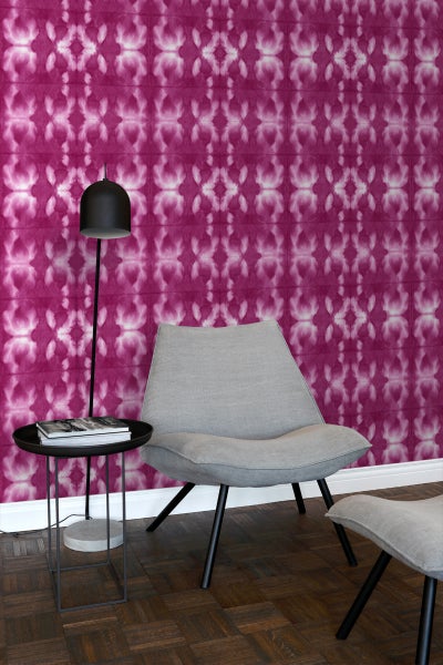 Dekoratives Zimmer mit gemusterter Tapete, Sessel, Beistelltisch und Stehleuchte